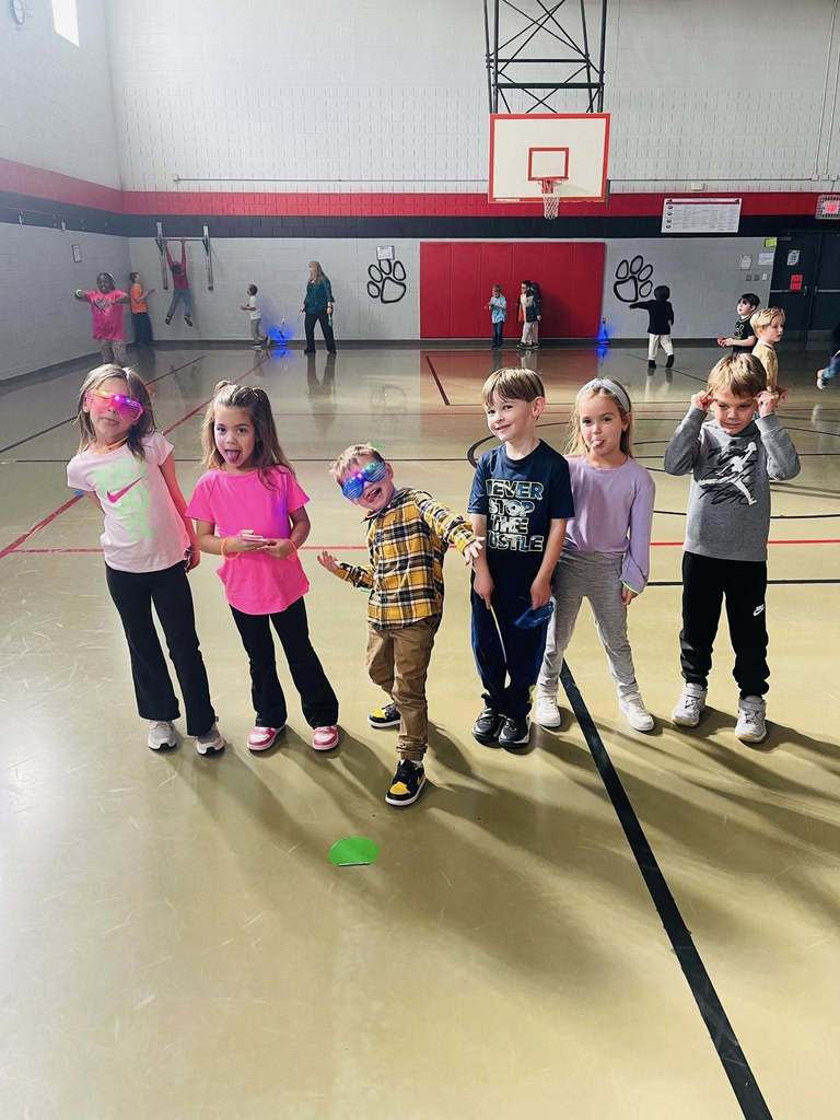six students stand together making silly faces