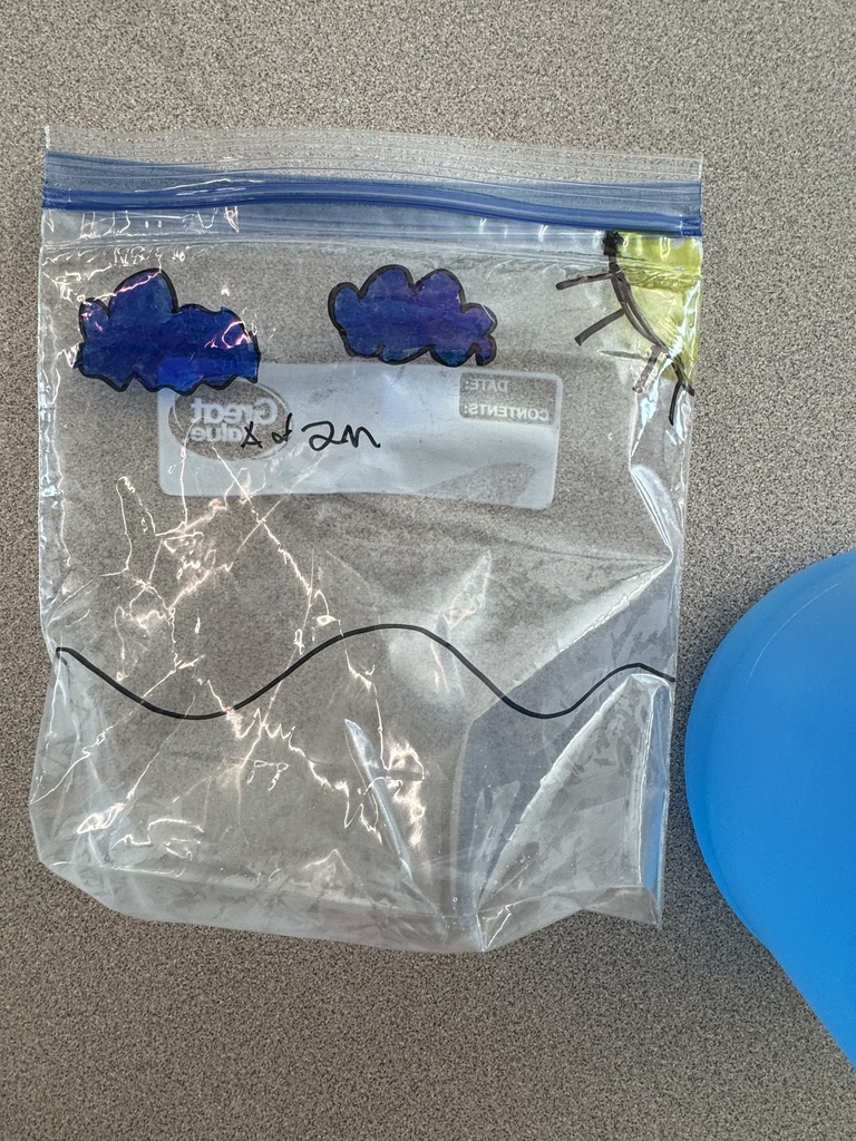 A bag with clouds, sun, and water drawing.