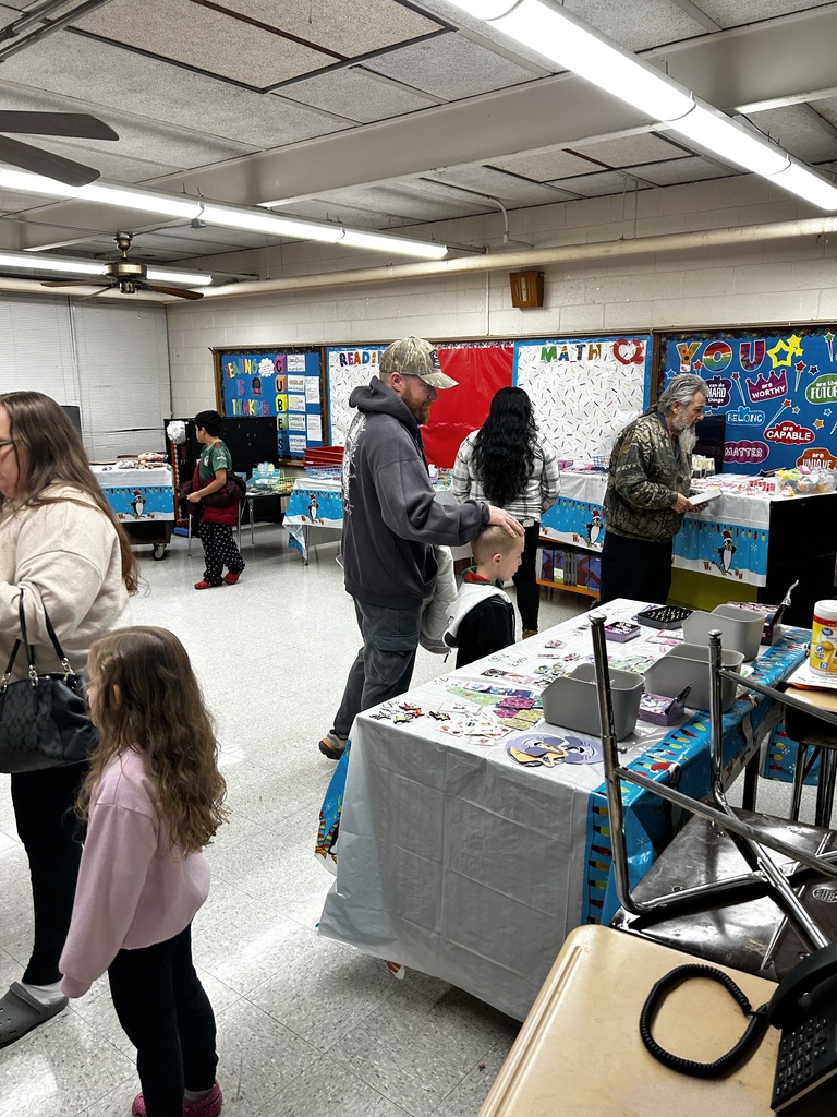 Parents and students are seen shopping the Holiday Shoppe in a classroom. 