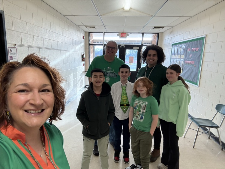 students and staff in green  