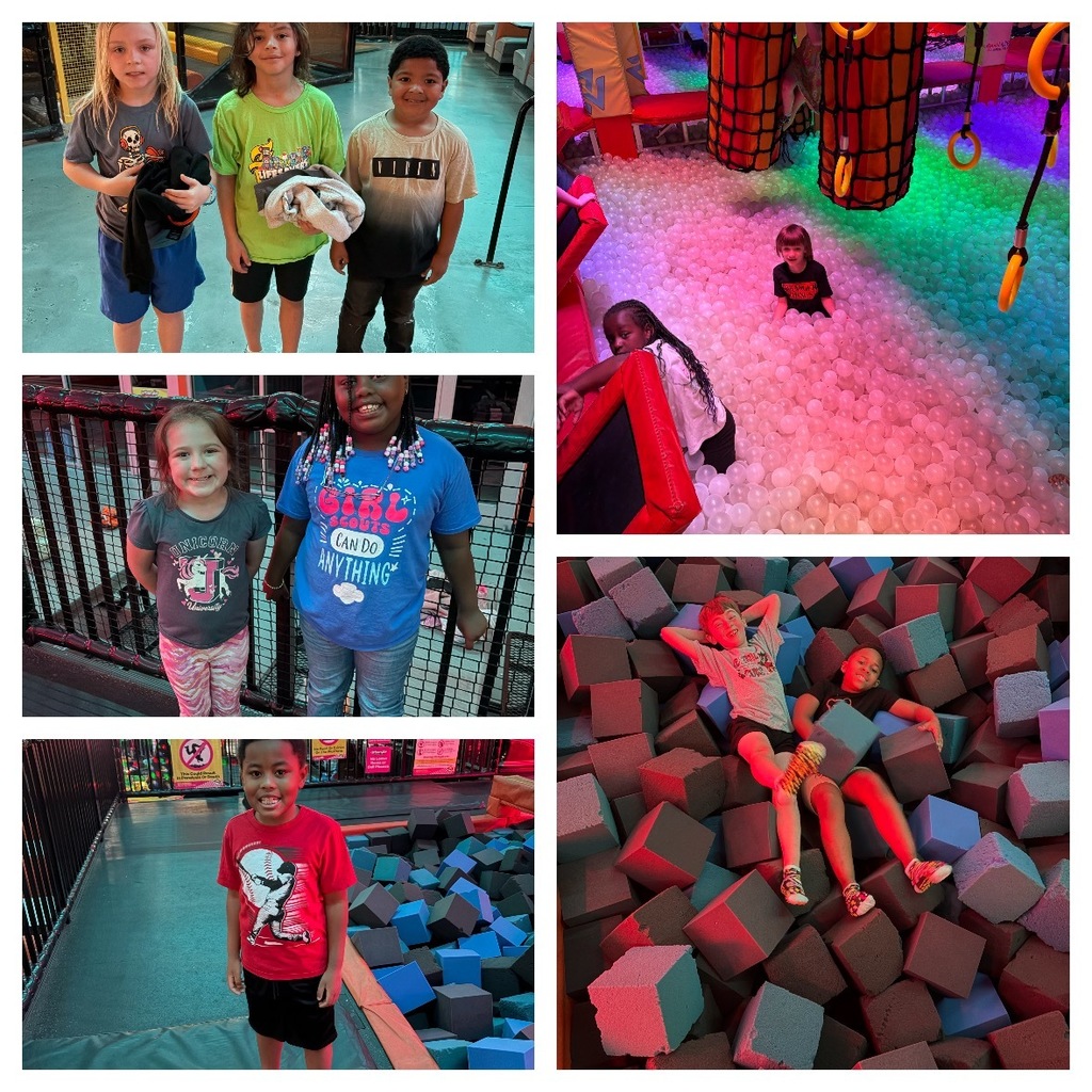 Top Left: Three children stand side-by-side smiling at the camera in a brightly lit indoor space. The child on the left has blonde hair, wears a grey t-shirt with a skeleton graphic and blue shorts, holding a black garment. The middle child has brown hair, wears a light green t-shirt printed with "Flippers" and black shorts, holding a light-colored towel or blanket. The child on the right has dark hair, wears a two-tone t-shirt (white fading to black) with "NITRO" printed on it, and dark pants. Top Right: A wide shot of a large ball pit filled with translucent white balls illuminated by vibrant pink, purple, and green lights. Three children are visible in the pit: one small child sits in the center looking at the camera, another child with long dark hair rests on a red padded barrier on the left edge. Giant cylindrical net structures with yellow rings for climbing or swinging are visible in the background, along with red padded walls. Middle Left: Two girls stand smiling at the camera in front of a dark metal fence or netting typical of an indoor play structure. The girl on the left has light brown hair and wears a grey t-shirt with a unicorn graphic and text reading "UNICORN YOU CAN BE ANYTHING" with patterned leggings. The girl on the right has dark braided hair adorned with beads, wears a blue t-shirt printed with "GIRL CAN DO ANYTHING," and light-colored jeans. Bottom Left: A young boy stands smiling next to a large foam pit filled with blue and black foam cubes. He wears a red t-shirt with a white baseball player graphic and black shorts. The floor beneath him is padded with orange and blue sections. Bottom Right: Two boys lie relaxed amidst a large pit filled with foam cubes in shades of grey, black, and light blue, illuminated with red and blue dramatic lighting. The boy on the left lies on his back with arms behind his head, wearing a grey t-shirt and patterned shorts. The boy on the right lies on his side holding a blue foam cube, wearing a dark t-shirt and dark shorts.