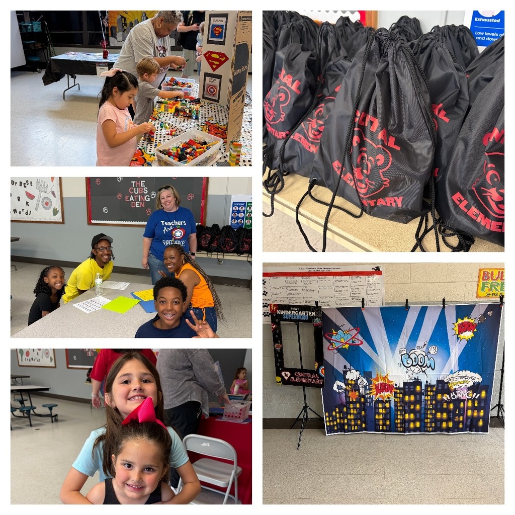 Students and families participate in indoor activities during a school event. Children build with colorful blocks at a table while staff assist nearby. A group of smiling students and adults pose together in a cafeteria space. Rows of black drawstring bags with the school logo sit on a table. A superhero-themed photo backdrop is set up for pictures. Two young girls smile at the camera, one standing behind the other.
