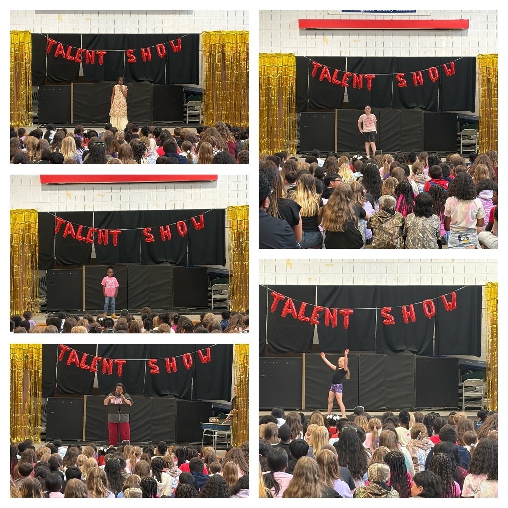 Students perform a variety of acts during a school talent show in the gym. A red “Talent Show” balloon banner hangs against a black backdrop with gold streamers on each side.