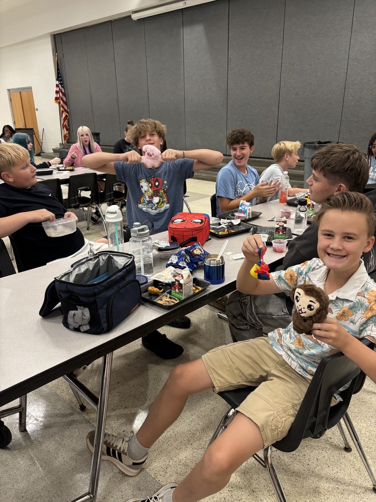 students in the cafeteria with prize ducks and slap bracelets