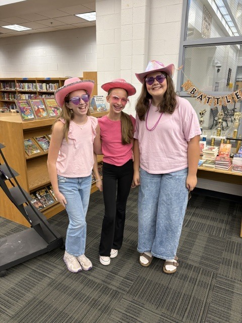 students in the library wearing cowboy hats and pink