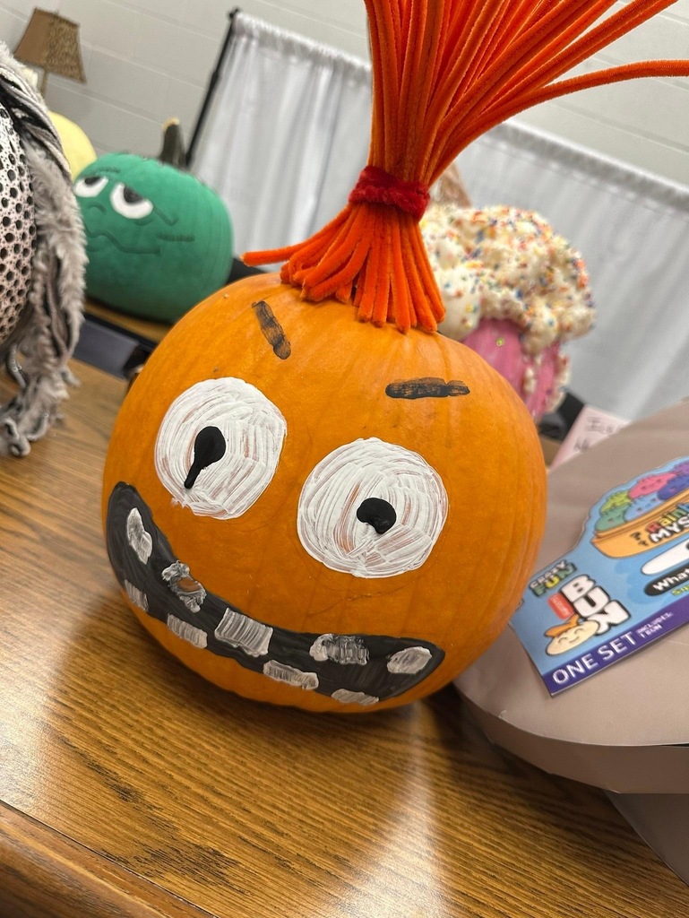 Rockingham County Middle pumpkin- An orange pumpkin with red hair, big eyes and teeth and eyebrows, making a crazy face