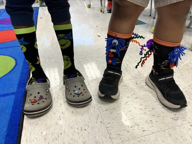 Red Ribbon Week- Monroeton Elementary crazy sock day: Left shows a student in knee-high black socks with the faces of the Ninja Turtles on them, right shows a student in calf-high socks that are black with monster faces made out of craft materials