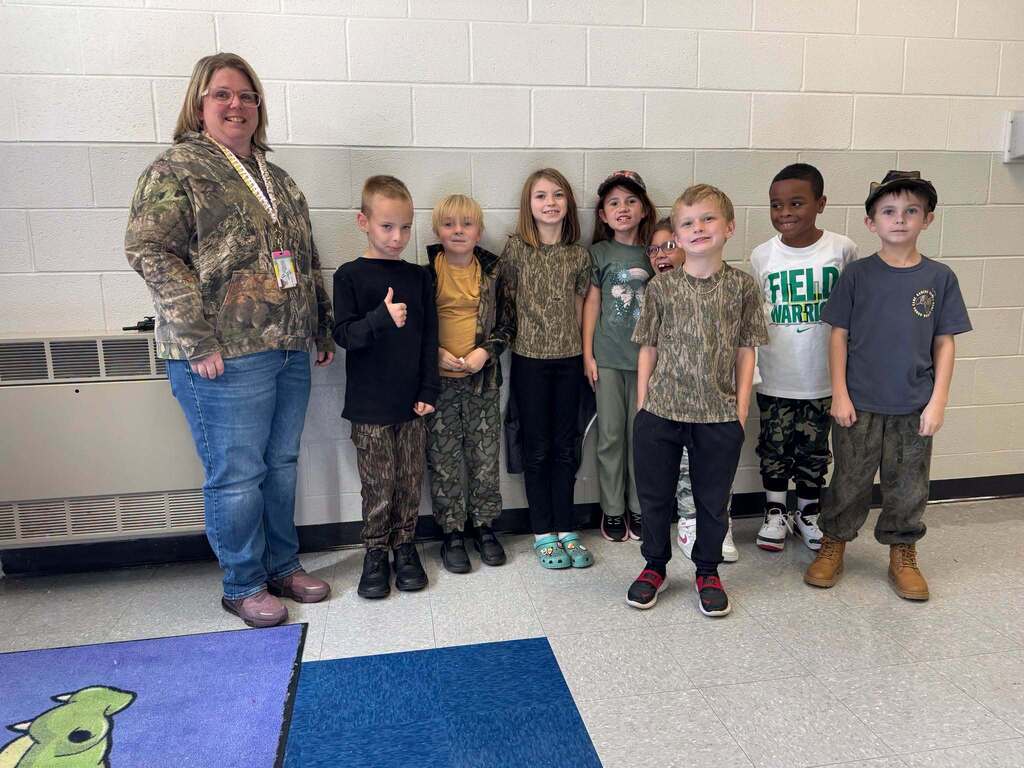 Red Ribbon Week- Lincoln Elementary Camo Day: A teacher on the left with 8 students beside her (3 girls, 5 boys) all dressed in some form of camo