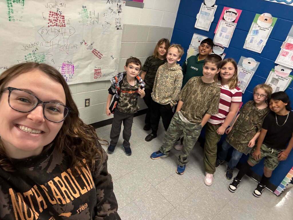 Red Ribbon Week- Lincoln Elementary Camo Day: Teacher taking a selfie with her 8 students behind her (2 girls, 6 boys) all dressed in some form of camo