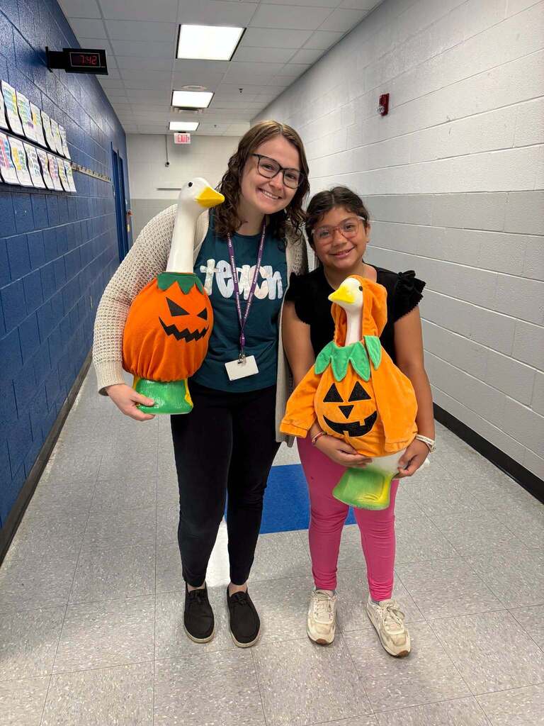 Red Ribbon Week- Lincoln Elementary Dress like a student/teacher day: a female teacher and student holding geese statues dressed in pumpkin costumes