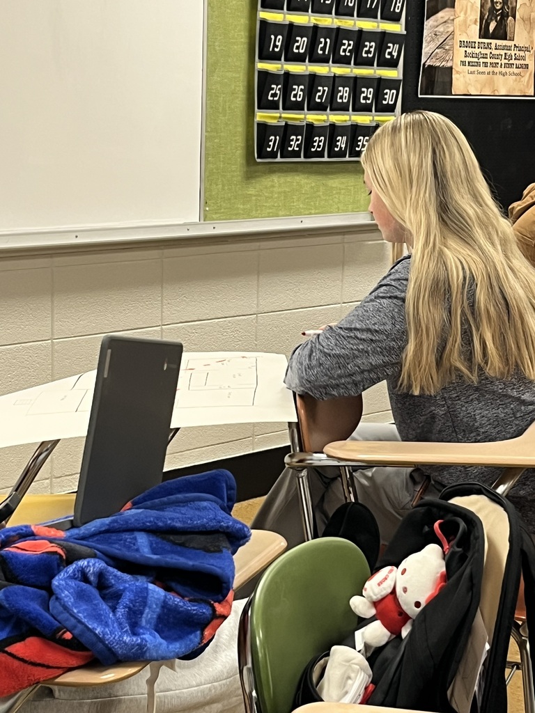 Rockingham County High School Public Safety class: A female student sitting at a desk inside a classroom working on a chart