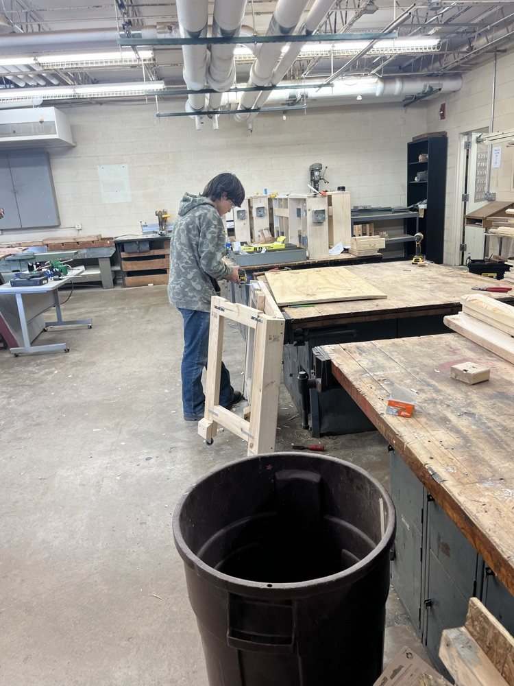 Elijah Stoneking working on making sure his table top will sit  level on the legs of the table