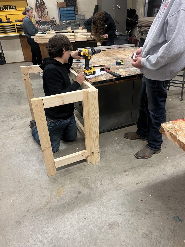Zeke Degelman and Gage Reed working on putting hinges on the legs 