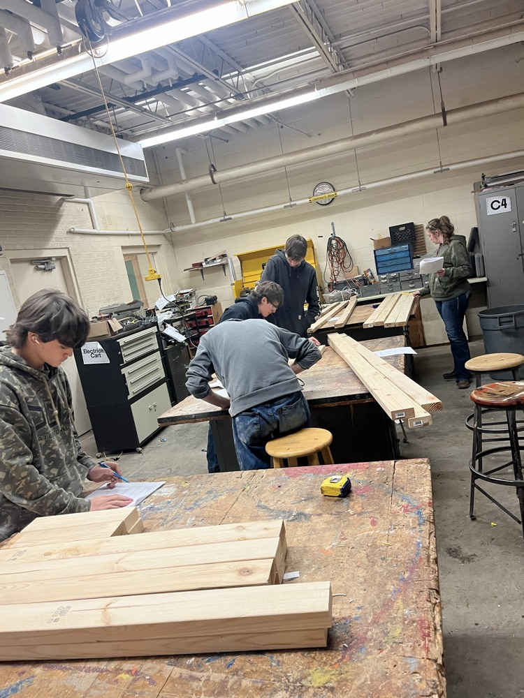 Building and Construction looking over blueprints for the tables