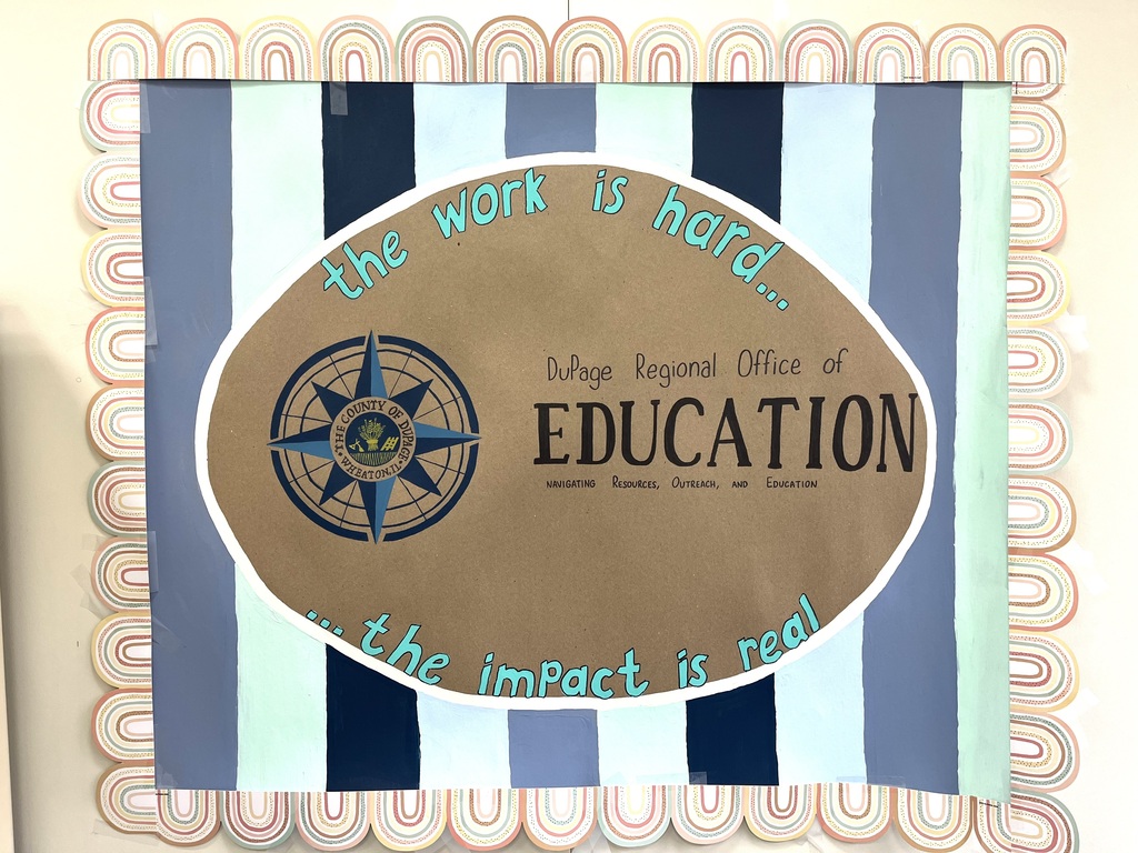 A framed poster with blue and white stripes displays a compass logo and text: "The work is hard... Impact is real."