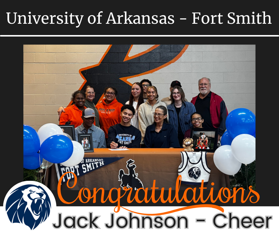 Jack Johnson sits at a signing table surrounded by family, friends, and supporters. The table is decorated with University of Arkansas–Fort Smith colors and balloons, celebrating his commitment to cheer at the next level.