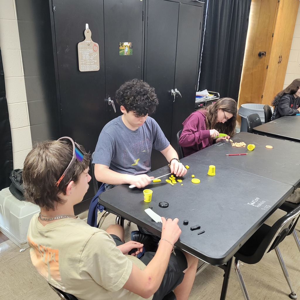 Roland Middle School students in Home Economics class practicing knife safety skills. Students are using plastic knives and Play-Doh to practice different cutting techniques while learning about proper knife handling and kitchen safety.