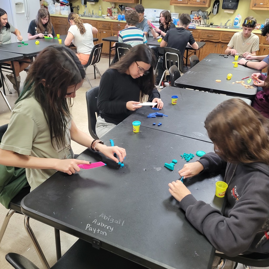 Roland Middle School students in Home Economics class practicing knife safety skills. Students are using plastic knives and Play-Doh to practice different cutting techniques while learning about proper knife handling and kitchen safety.