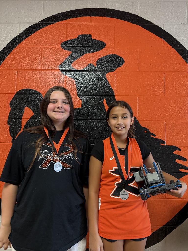 2 female students holding a robot 