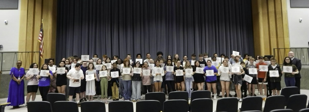 Students pose with their award certificates while being joined by school administrators during the PBIS Award Ceremony.