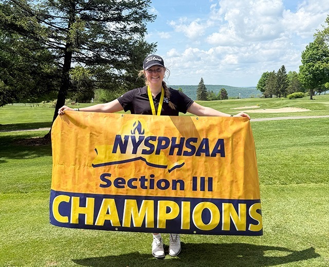 RFA junior Rachel O'Rourke displays the NYSPHSAA Section III Championship banner after winning the individual title.