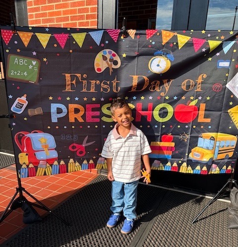 A preschool student celebrates the first day of school.
