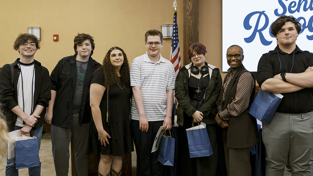 Students pose for a photo at the P-TECH Completion Ceremony. Pictured from left to right are: Gavyn Toepp, Adam Keith, Samantha Aldrich, Jeremy Edwards, Alexa Smith, Superintendent Nerlande Anselme, and Riley Mucitelli.