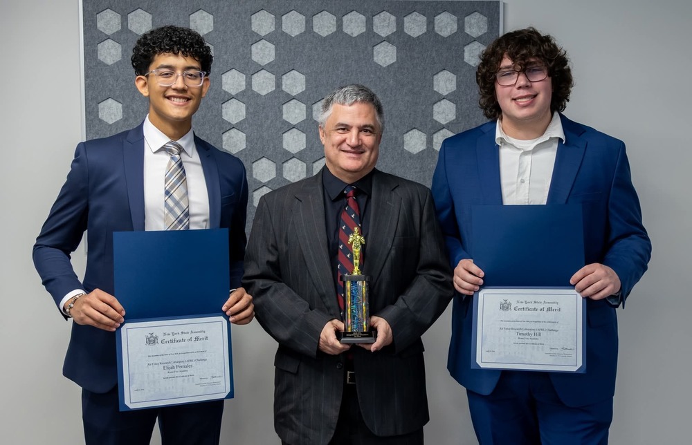 RFA senior Elijah Pomales, left, Teacher/Coach Albert Bangs, center, and senior Timothy Hill, right pose with their awards after winning the 2026 AFRL Challenge Competition.