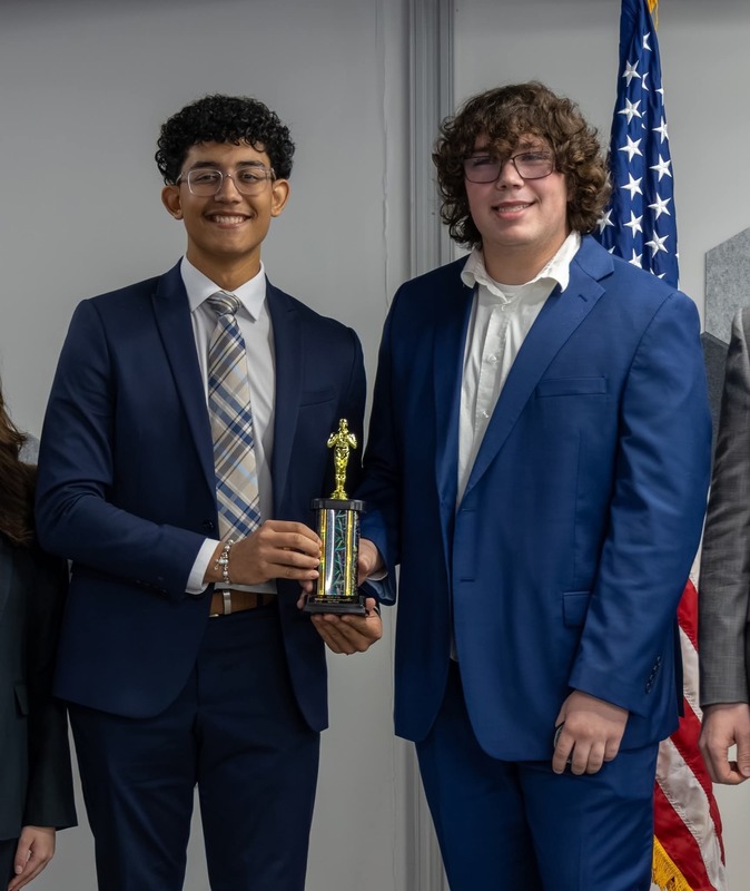 RFA senior Elijah Pomales, left,  and senior Timothy Hill, right, pose with the first-place trophy after winning the 2026 AFRL Challenge Competition.
