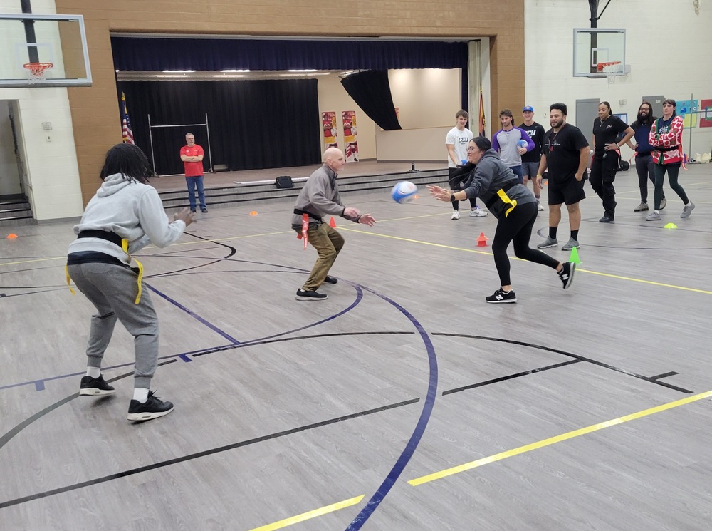 Roosevelt PE teachers participate in a rugby drill during an instructional clinic