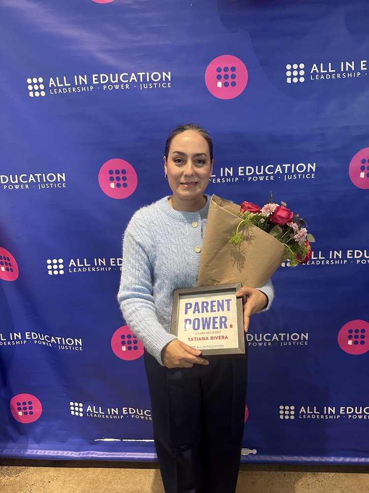Tatiana Rivera poses with a plaque that says "Parent Power"