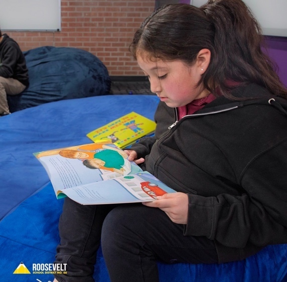 Girl reading a book while sitting 