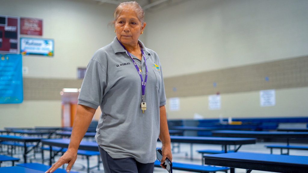 A custodian walks through the cafeteria ensuring cleanliness