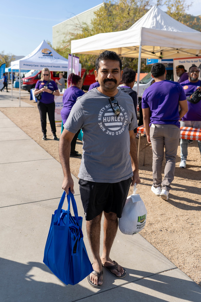 Man carrying a frozen turkey and a food bag