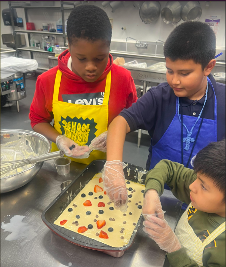 Boys adding fruit to their dessert for baking