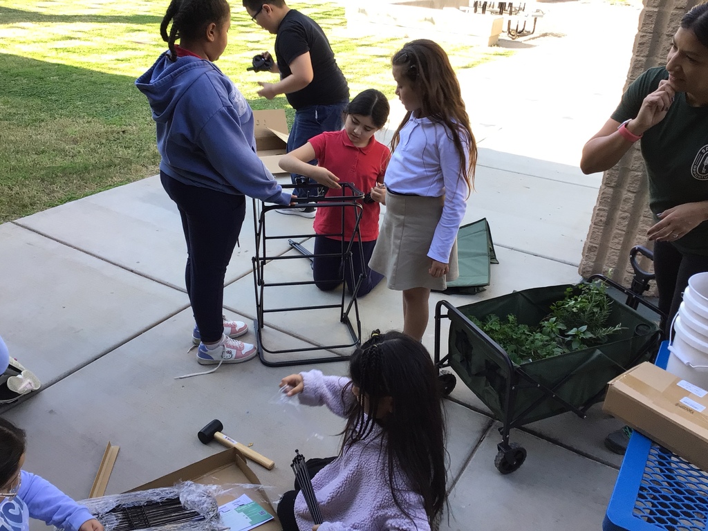 5 students assembling a cart for gardening