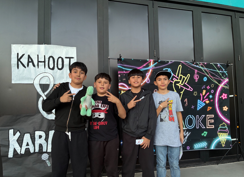 4 boys in front of karaoke sign and 1 winner holding a prize
