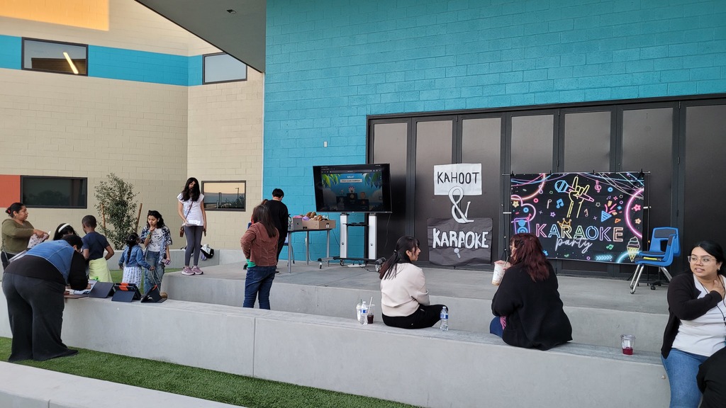 Outdoor courtyard with sitting areas and artificial turf with Karaoke signs