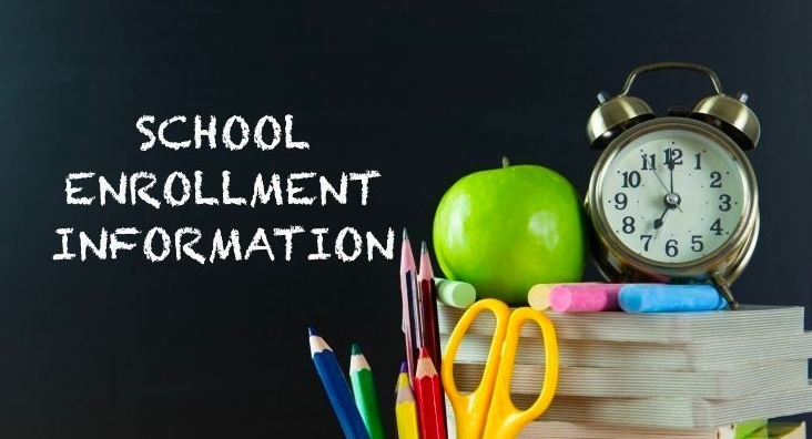 school enrollment information spelled out with chalk on the left side of a black yellow scissors, blue, red, yellow and black colored pencils. Next to pink, blue, green and yellow chalk, a green apple and a clock on top of what looks like four stacked books for a prop.