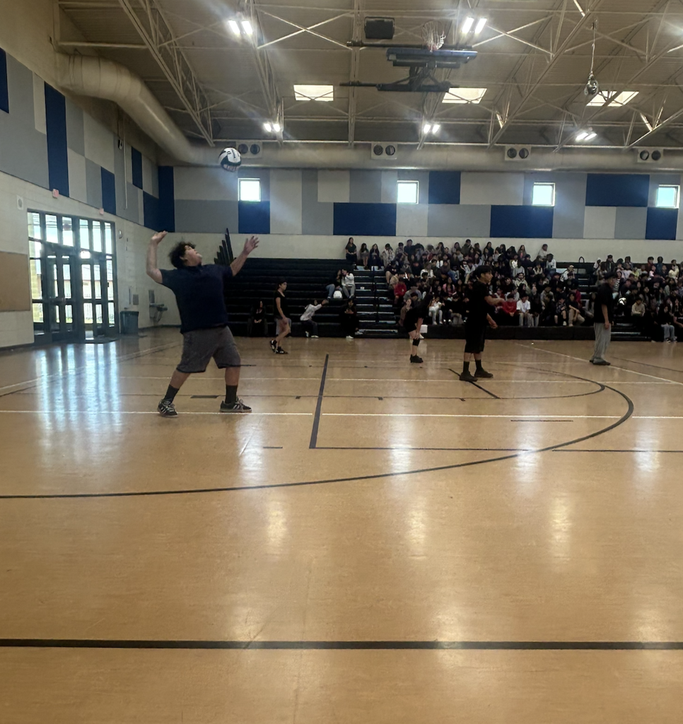 Student Athlete serves a volleyball