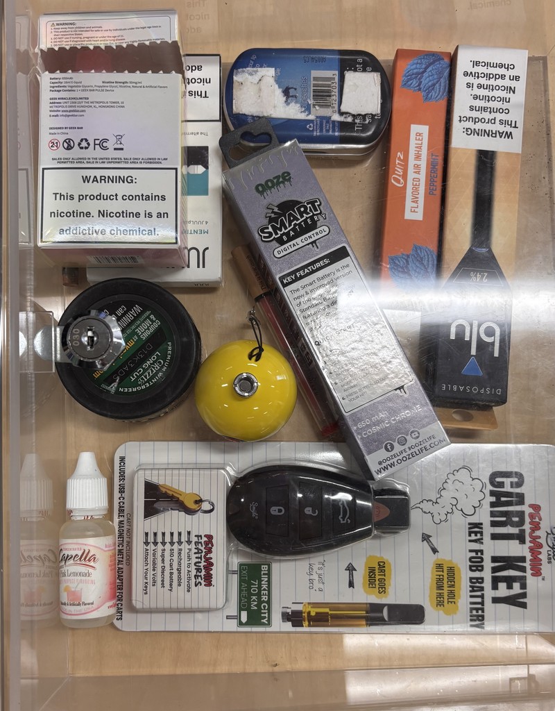 Disposable vapes and vape pods (rectangular and pen-shaped devices like the black and orange ones on the right)