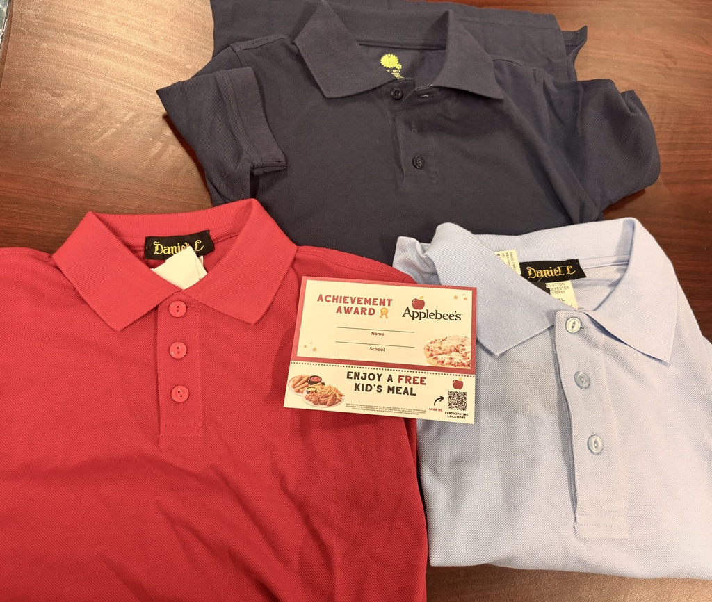 Three folded school uniform polo shirts in red, navy blue, and light blue are displayed on a wooden table alongside an Applebee’s free kids meal award certificate. The image promotes a school uniform donation drive to support students and families in need.