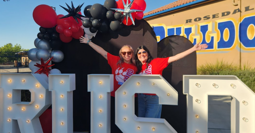Teachers In Front of a sign