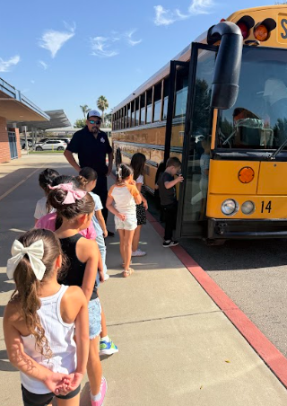 students lined up by  a bus