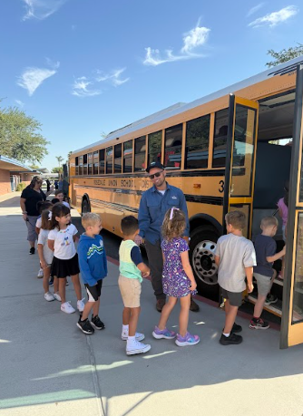 students lined up by  a bus