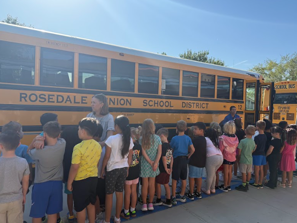 students lined up by  a bus