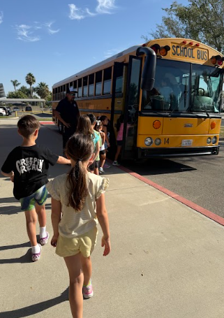 students lined up by  a bus