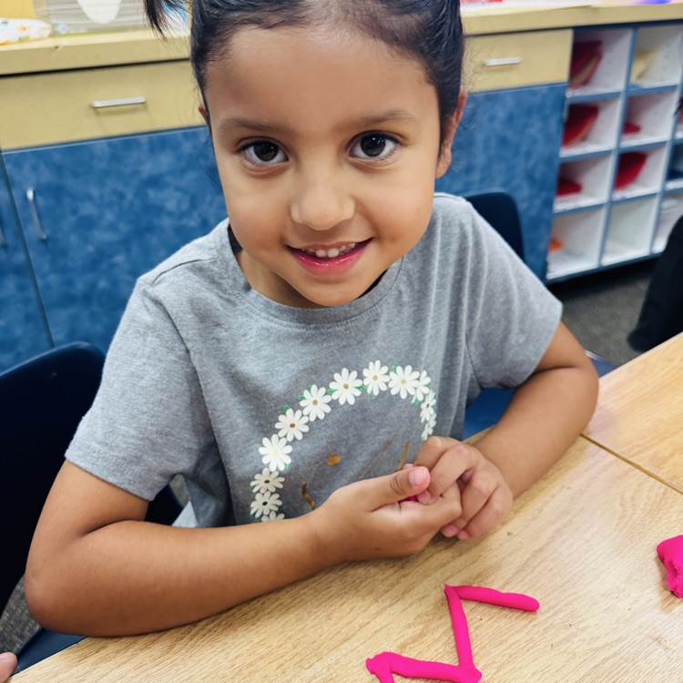 little girl with letter w shaped with playdoh