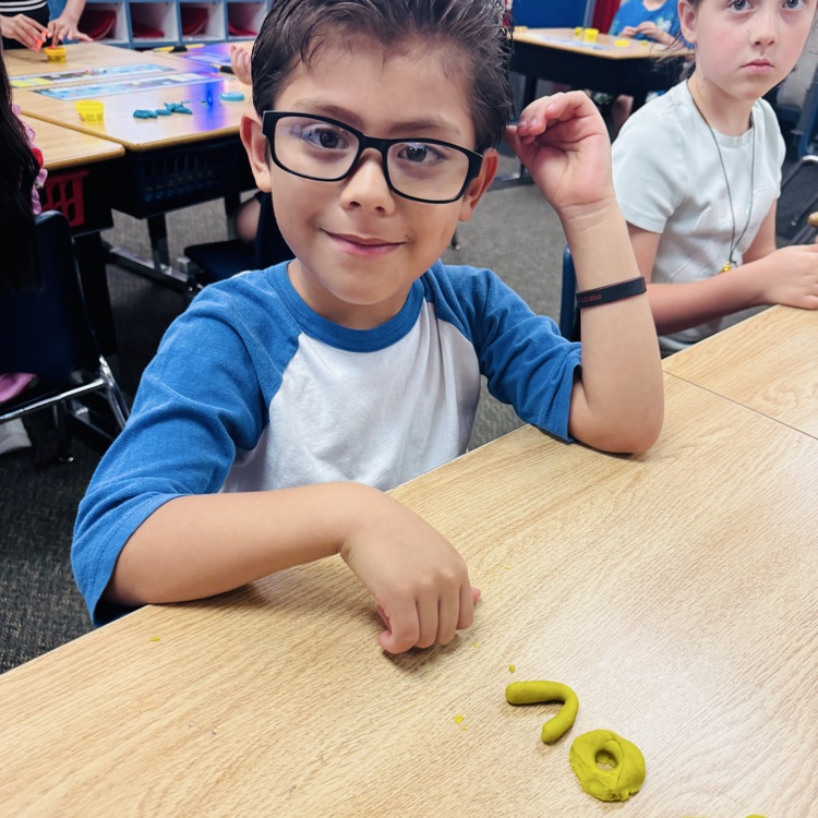 boy forming letters with playdoh