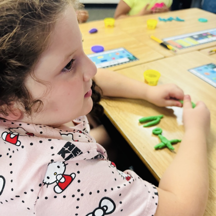 student shaping the word “not” out of playdoh